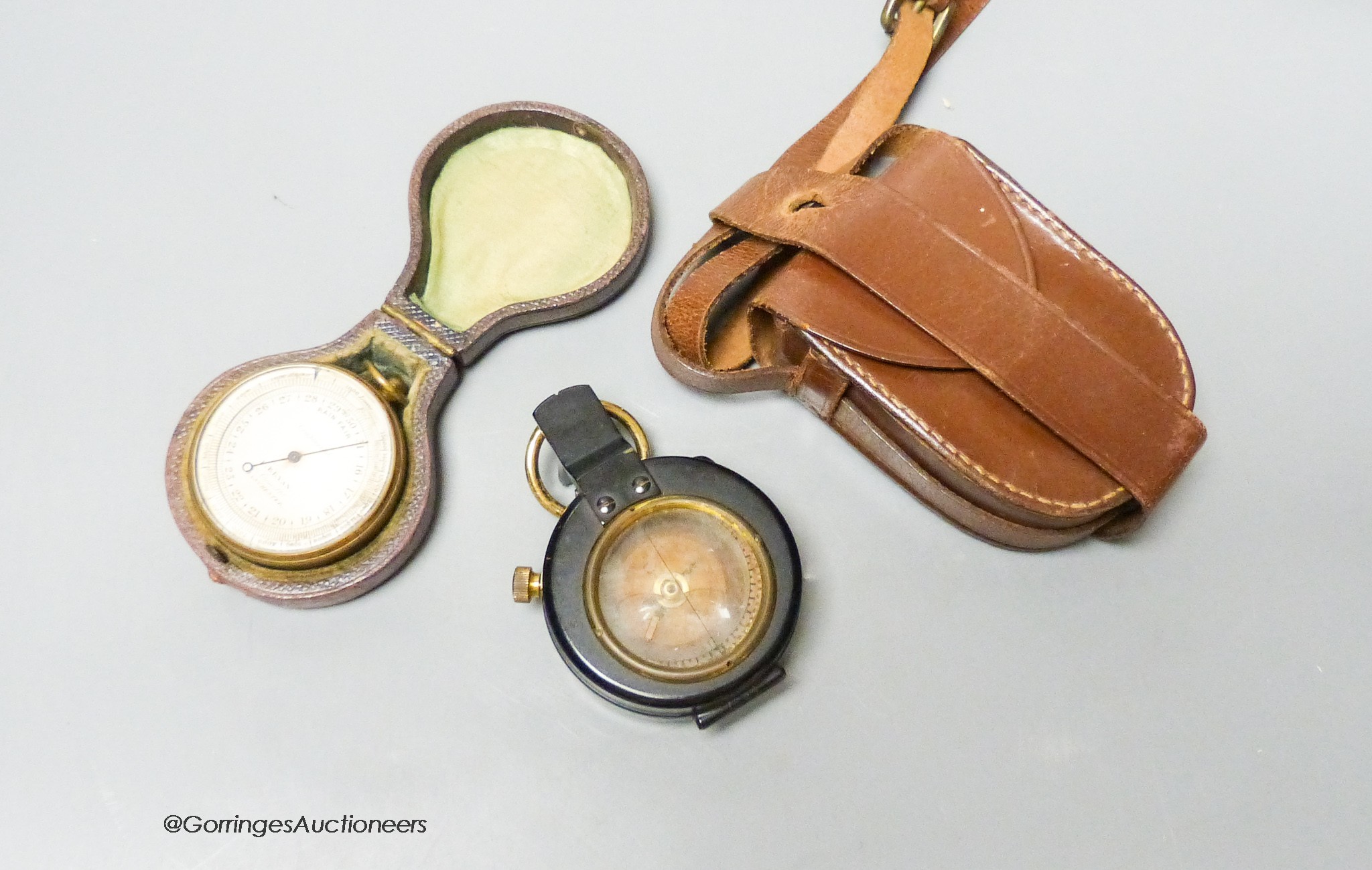 A small leather-cased military compass together with a cased compensated pocket barometer, E.Bryan, Manchester (2)